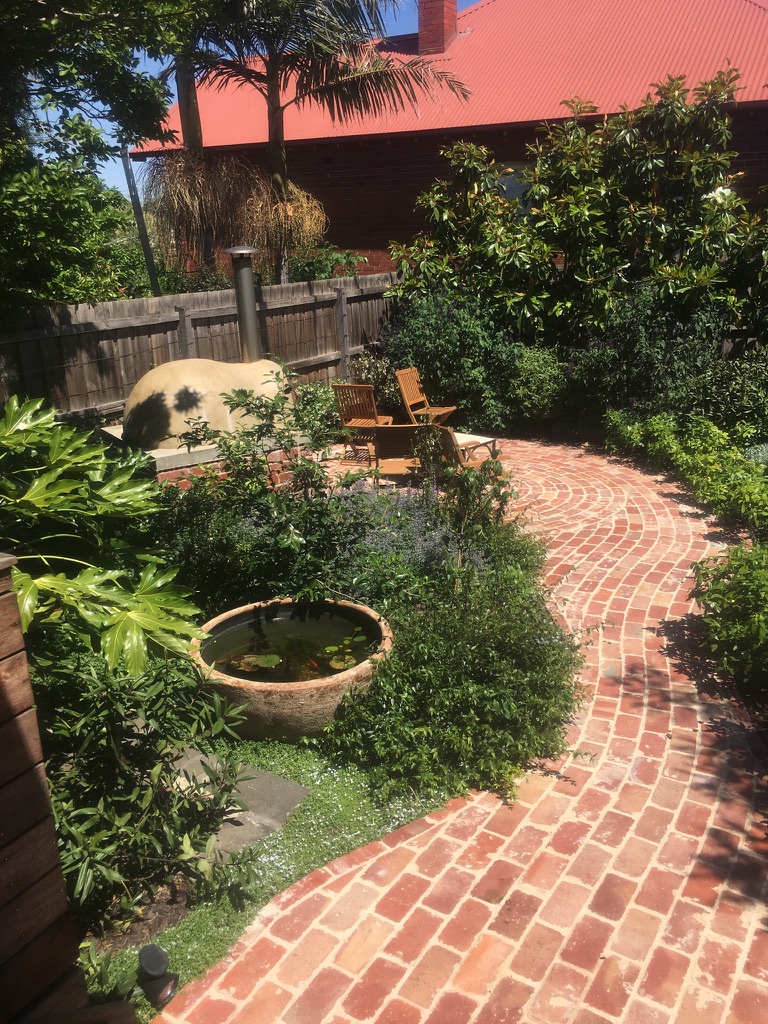 Mature Northcote garden with pizza oven, chairs and table